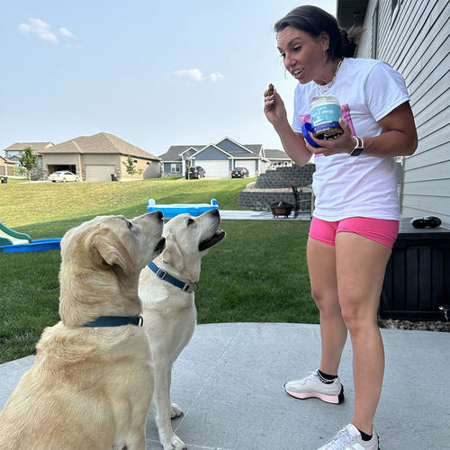 Women feeding itch and allergy chews to her two dogs.